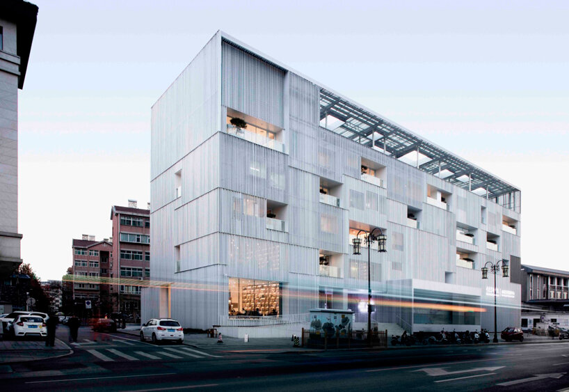 punched aluminum plates fold corrugated facade around TAOA